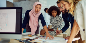 Group of employees looking over project plans in a decision-making meeting